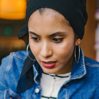 Smiling woman in a denim jacket and hijab