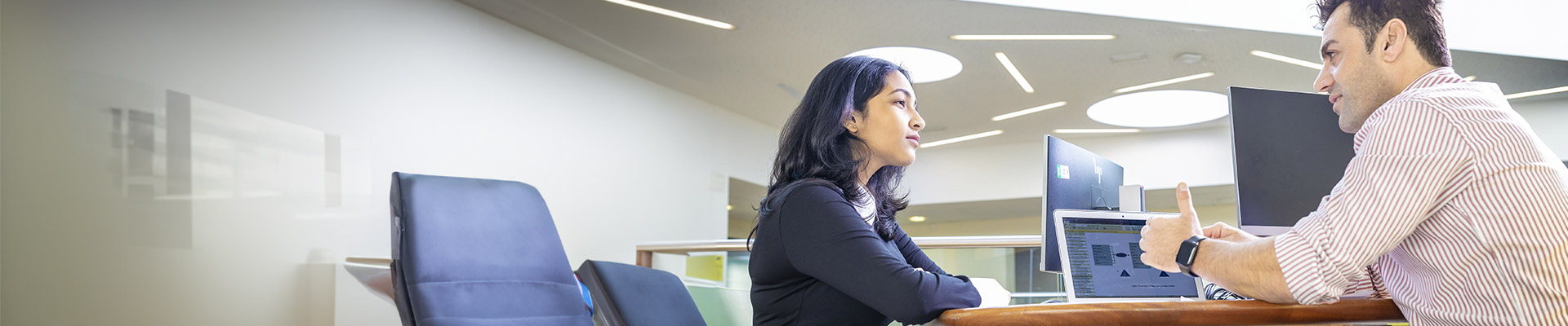 Woman and man working together in a library