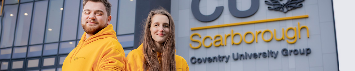 Two people wearing yellow stood outside of CU Scarborough