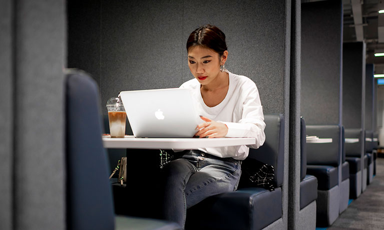 Student sat working on her laptop