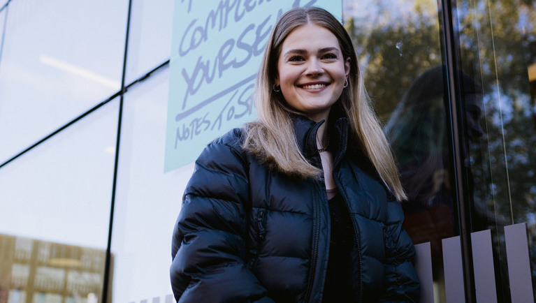 Smiling female student standing outside the Student Hub