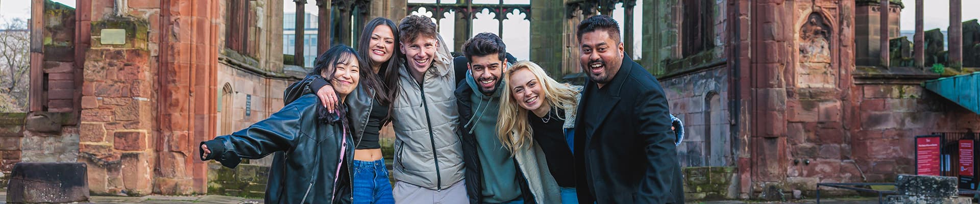 Group of students stood together in the Coventry Cathedral ruins