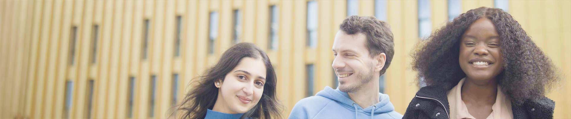 Close up of three students smiling looking at the camera