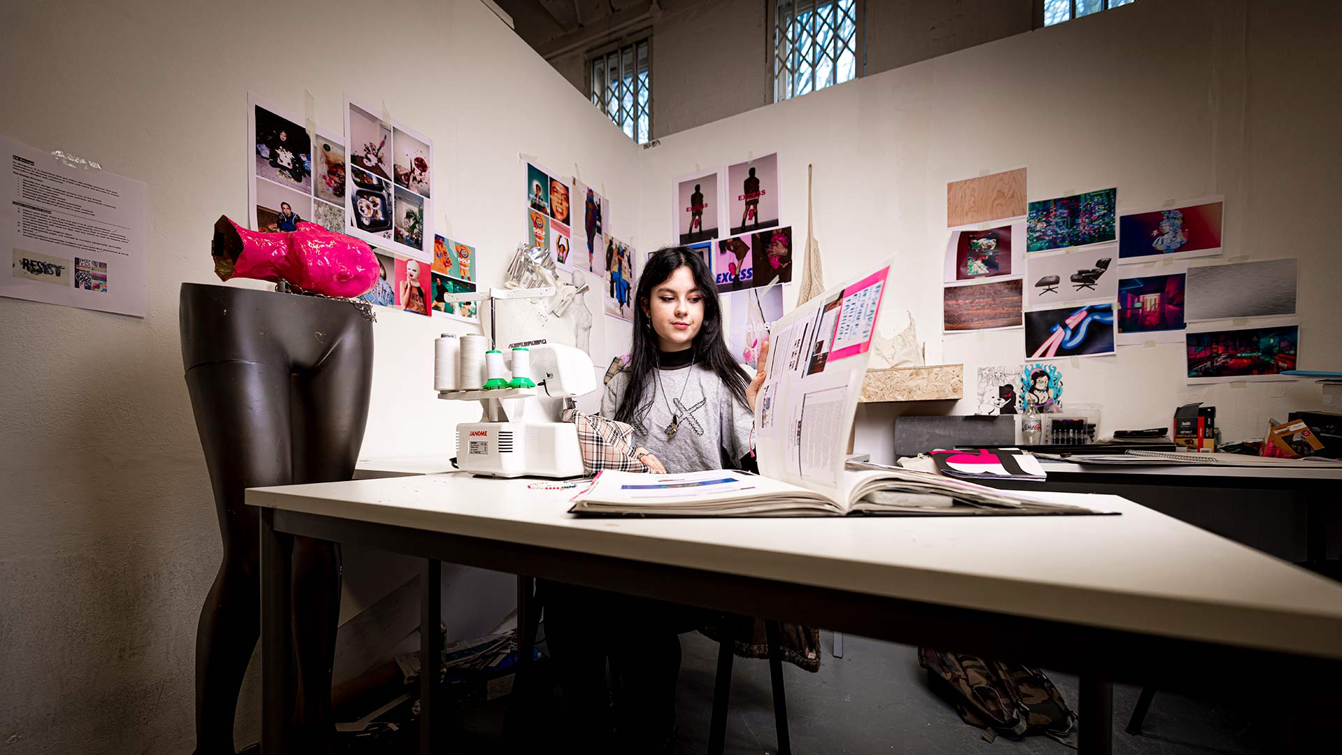 female smiling while overlooking a sewing fabric book