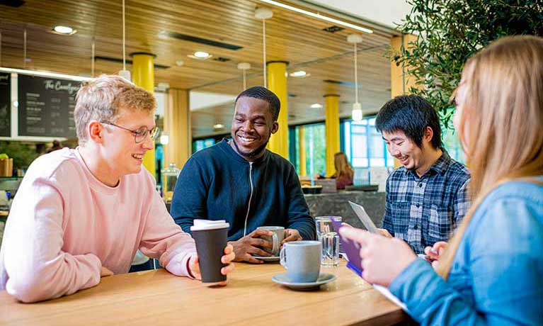 A group of students chatting in the Courtyard Cafe in The Hub.