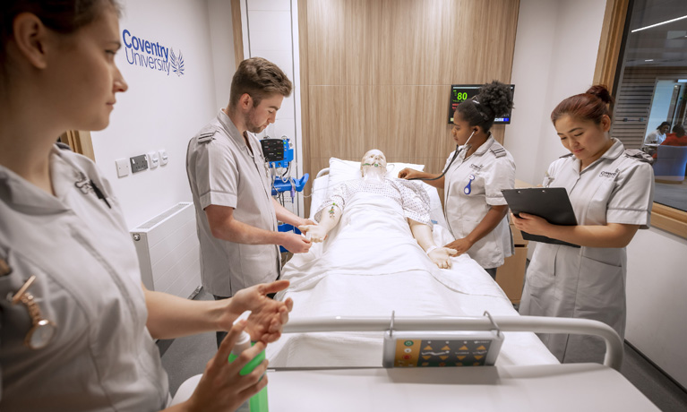 Students and a tutor with a manikin in the hospital ward