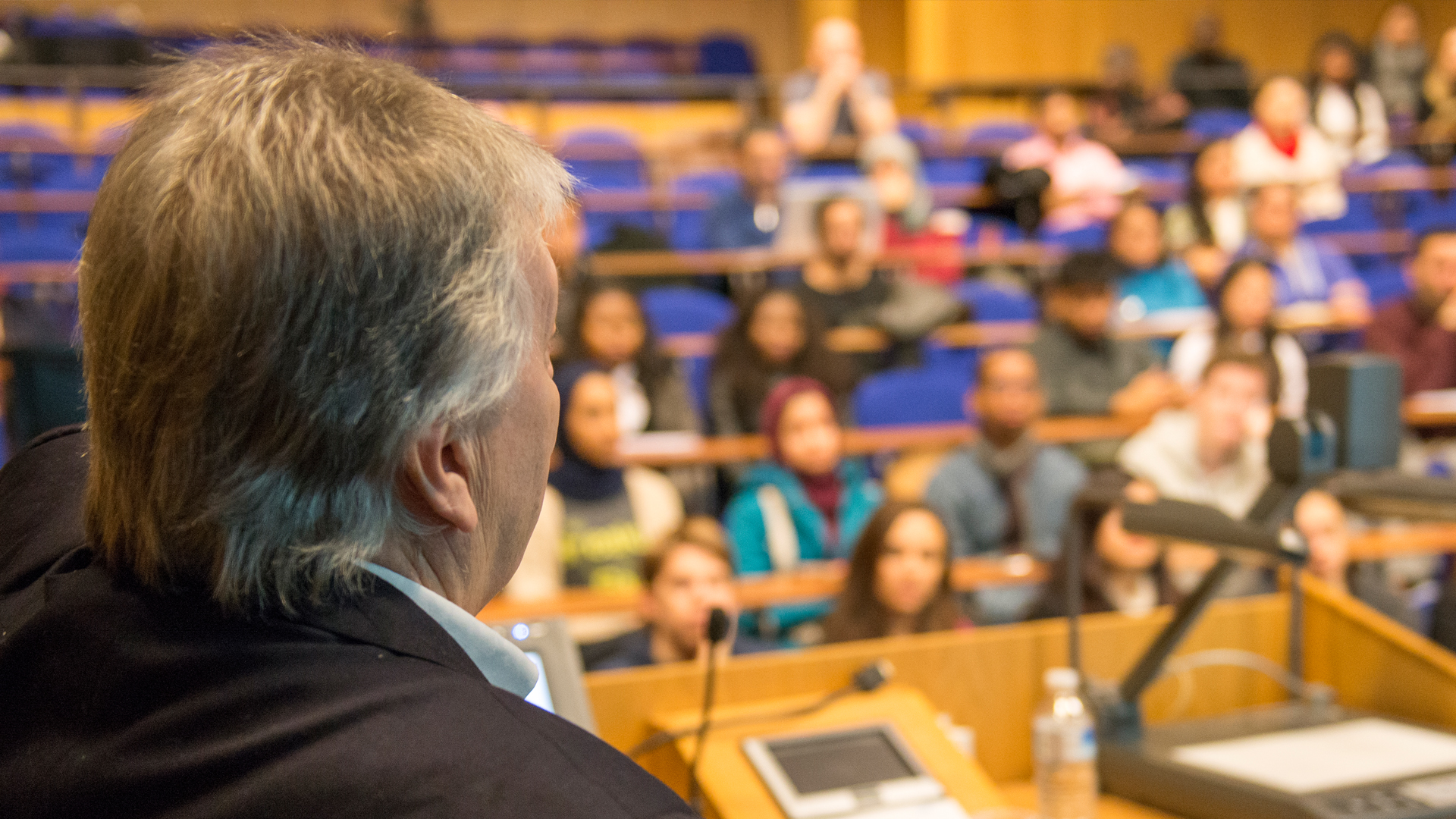 Lecturer facing students in a lecture theatre 