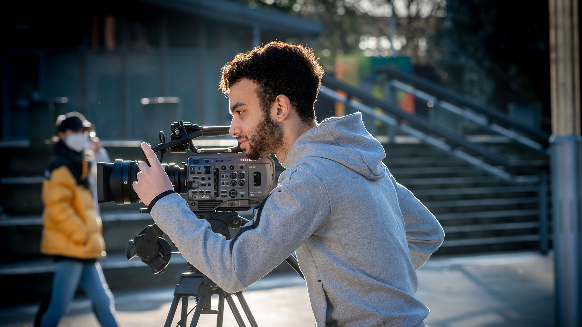 Man leaning over a camera as he films