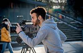 Man leaning over a camera as he films