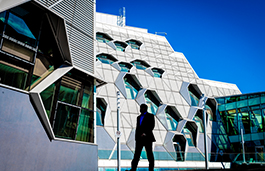 Student walking past the engineering buildng on a sunny day