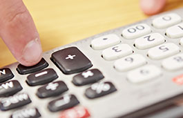 Close up of a person using a calculator.