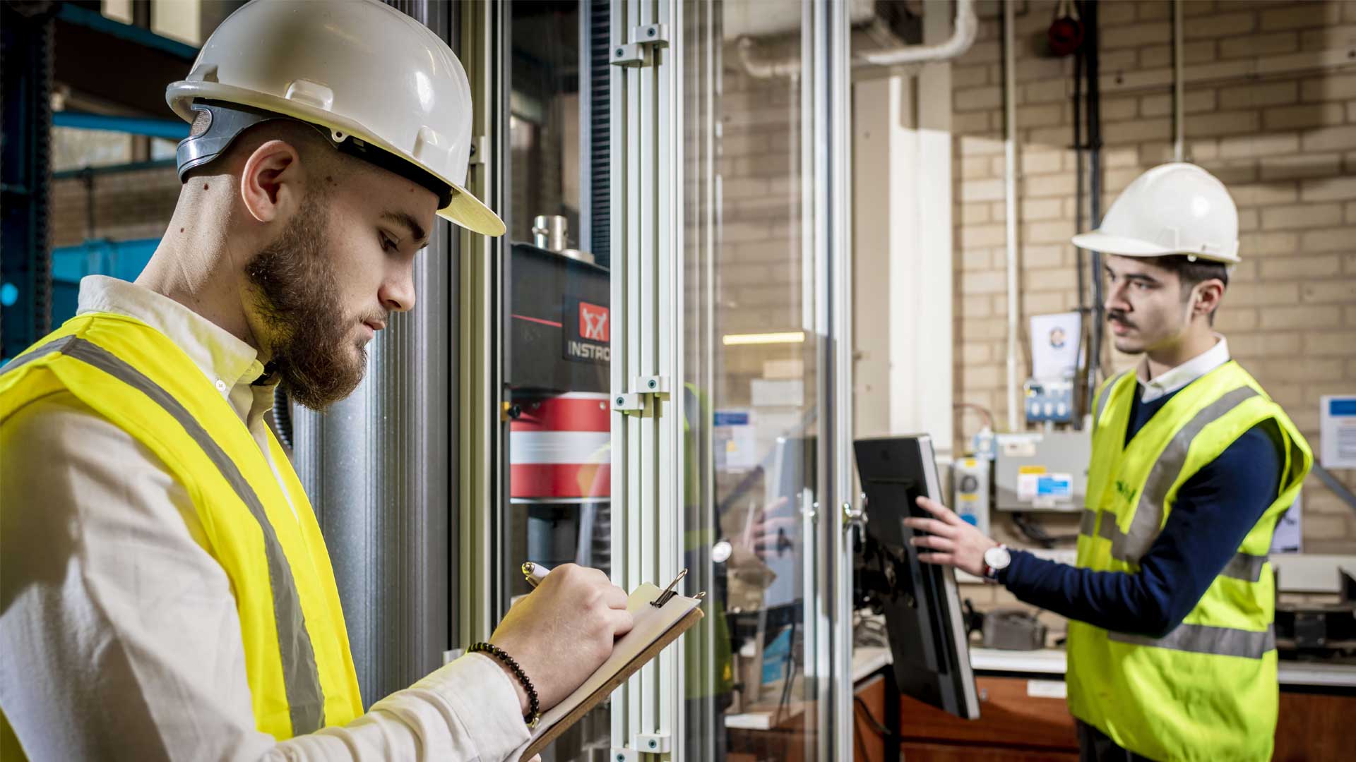 student in high vis with clipboard in engineering workshop