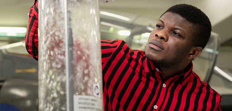 male student working with a wind tunnel 