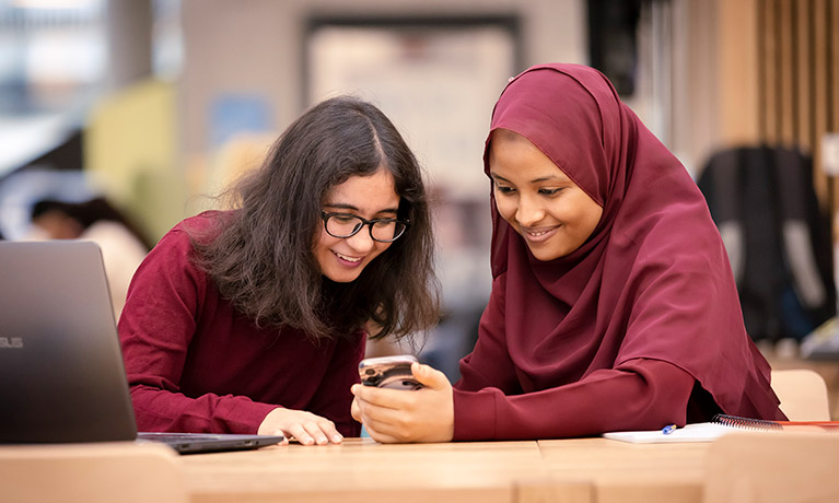 Two women looking at a phone together