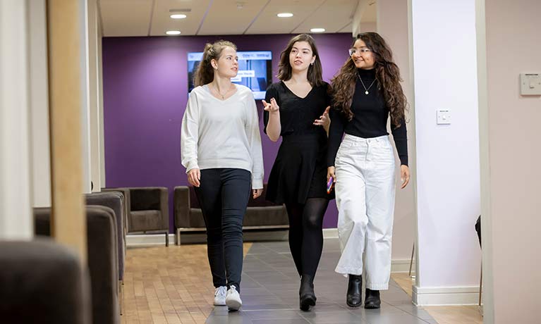 Three students walking in a corridor 