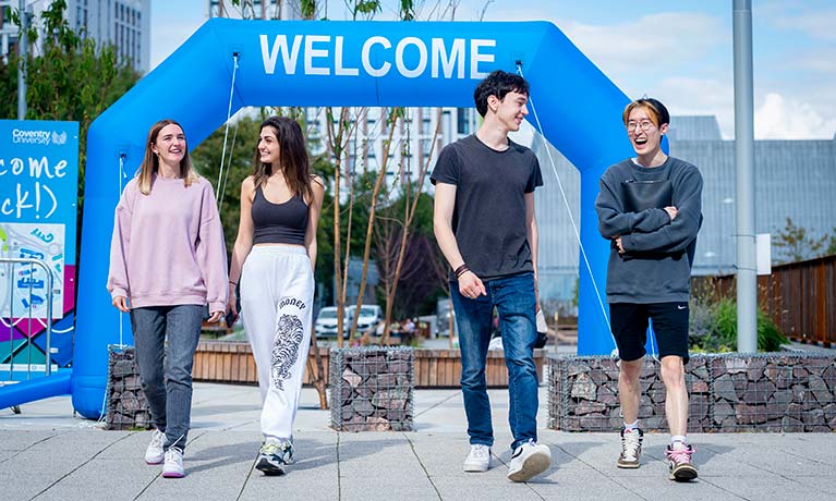 Four students walking through campus during welcome week