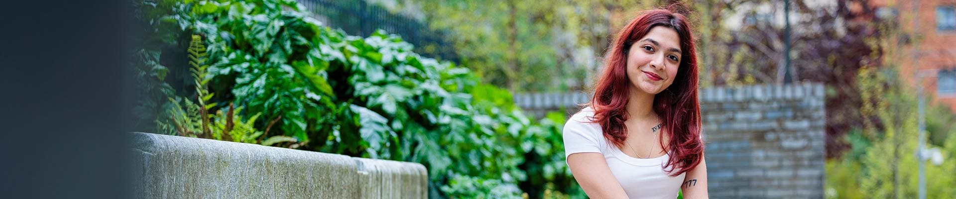 A student sitting outside in the campus grounds