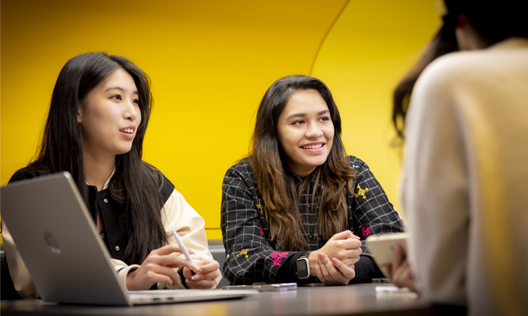 Students chatting in a social space inside The Hub.