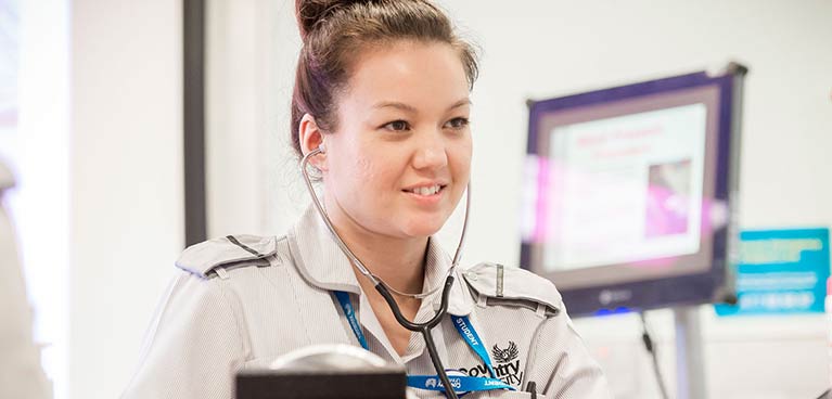 A student wearing a Coventry University nursing uniform and a stethoscope