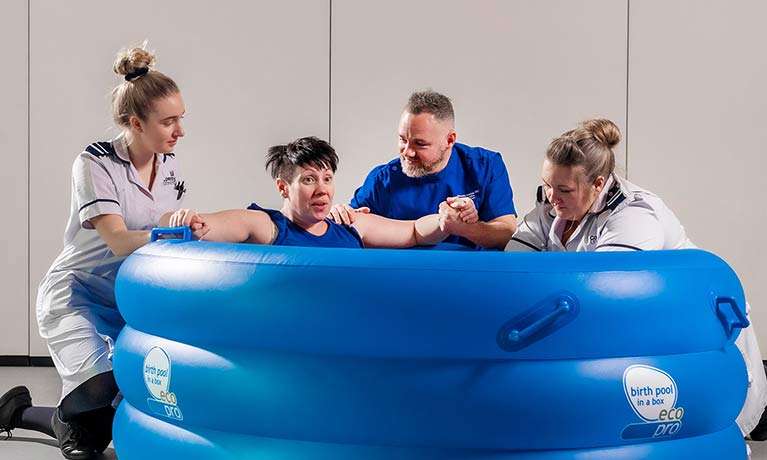 Woman giving birth in a birthing pool