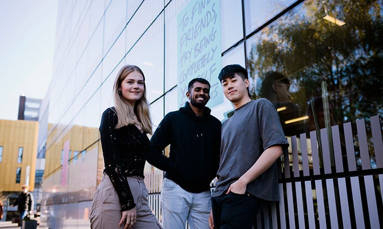 Three students leaning against the hub windows