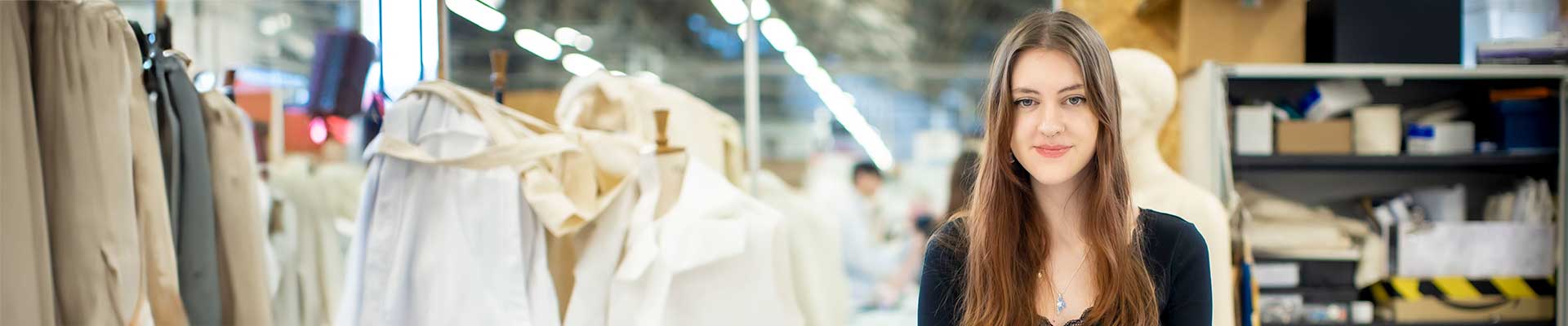 Female student sat in a design studio surrounded by textiles