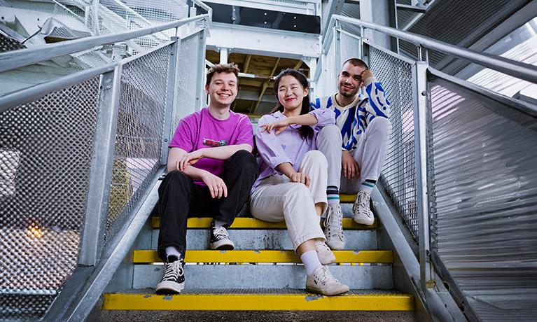 Two students sat on a staircase outside