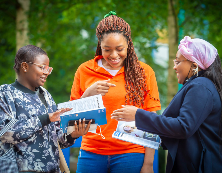 A young person in a bright orange top with two older people