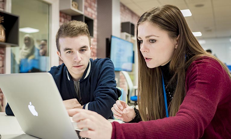 A lecturer and student looking at a laptop