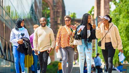 group of five students walking in the campus