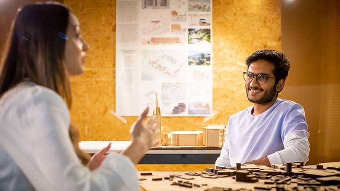 Two students sat discussing their art work