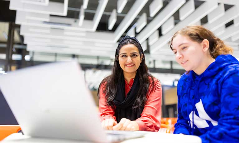 Two people working together with a laptop in front of them