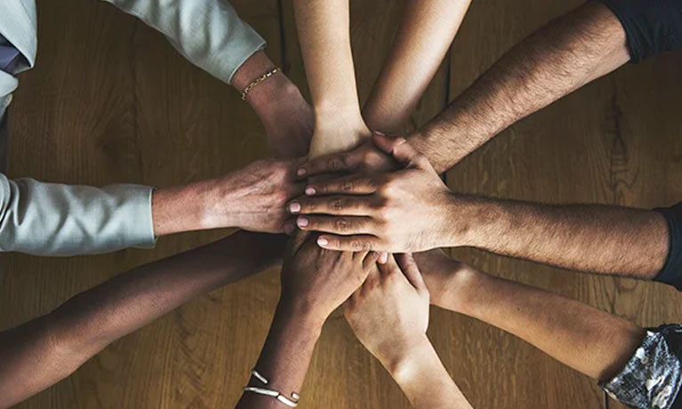 Five peoples hands on top of each other