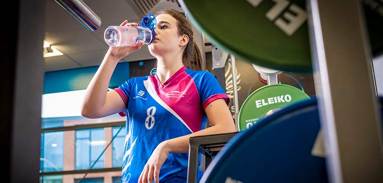 sports student drinking from a water bottle