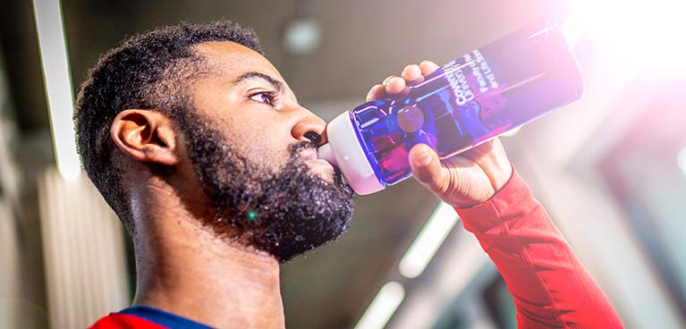 Man drinking water out of a sports bottle