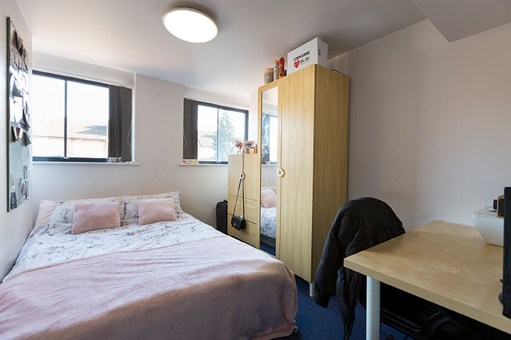 Double bed, wardrobe and desk area in an ensuite room