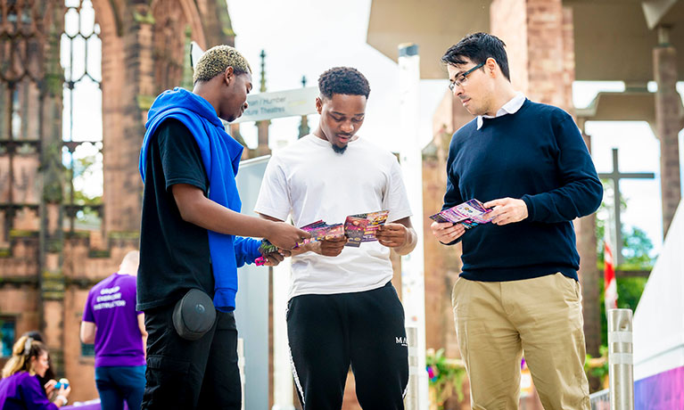 Students talking in front of the Coventry Cathedral