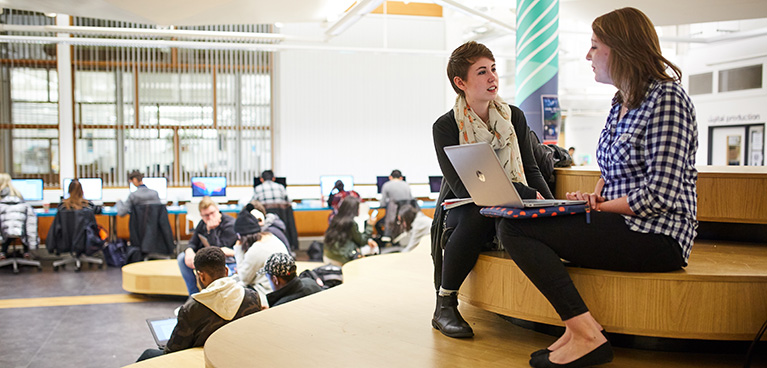 Students sitting in a library social space