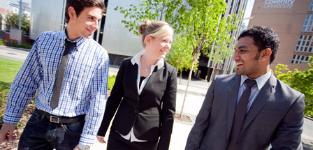 three people walking in front of an old building