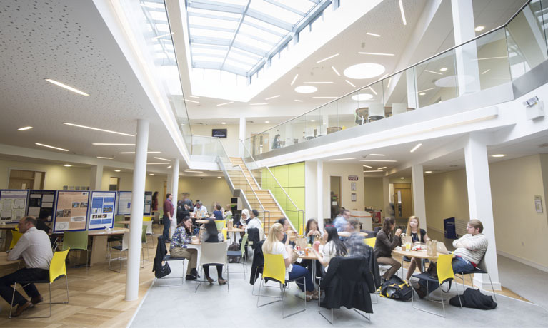 Atrium with people sitting at tables on chairs