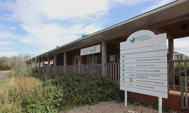 CAWR building with plants growing around it