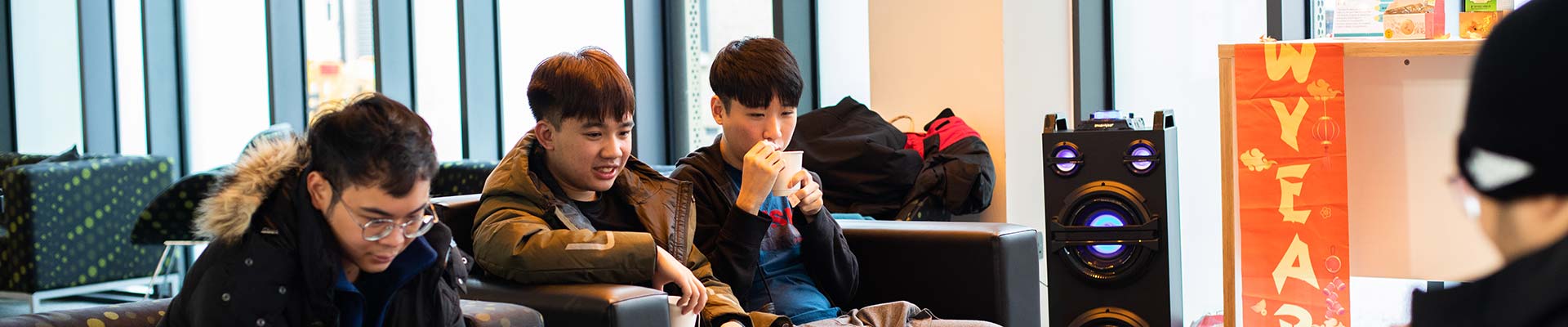 Three asian students eating in a communal area