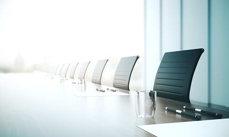 empty board room chairs pulled in against the table