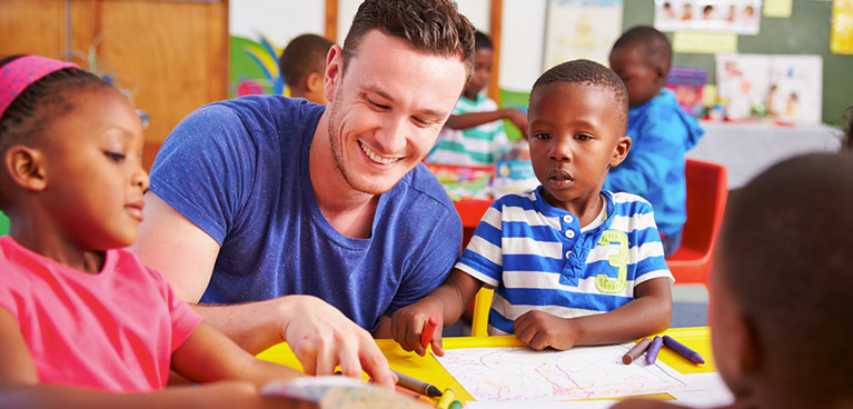 A student helping young shcool students with their work