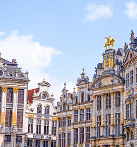 A golden statue on the top of old buildings in Brussels