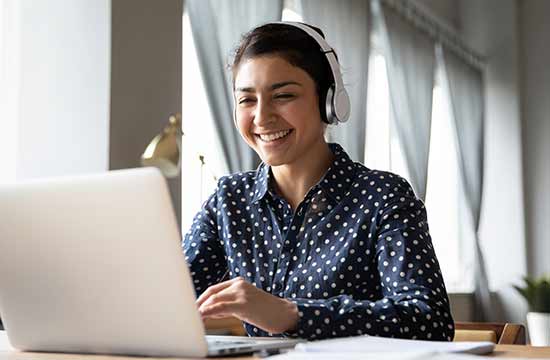 Student working on their laptop with headphones on