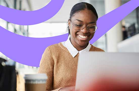 Smiling female wearing glasses looking at a laptop with graphic lavender swirl in background