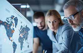 Close up of a man and woman looking at a screen showing map of the world 