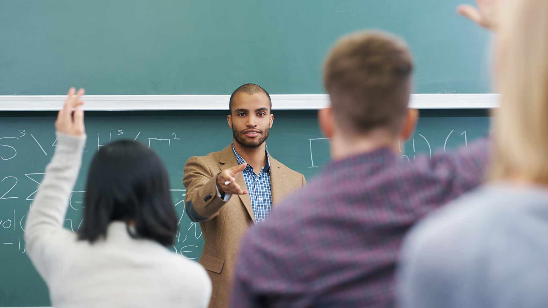 A teacher helping an older student in class.