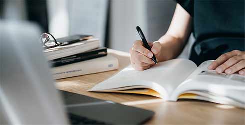 close up of a person writing in a notebook